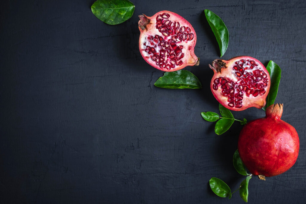 sliced pomegranate fruit on a black background